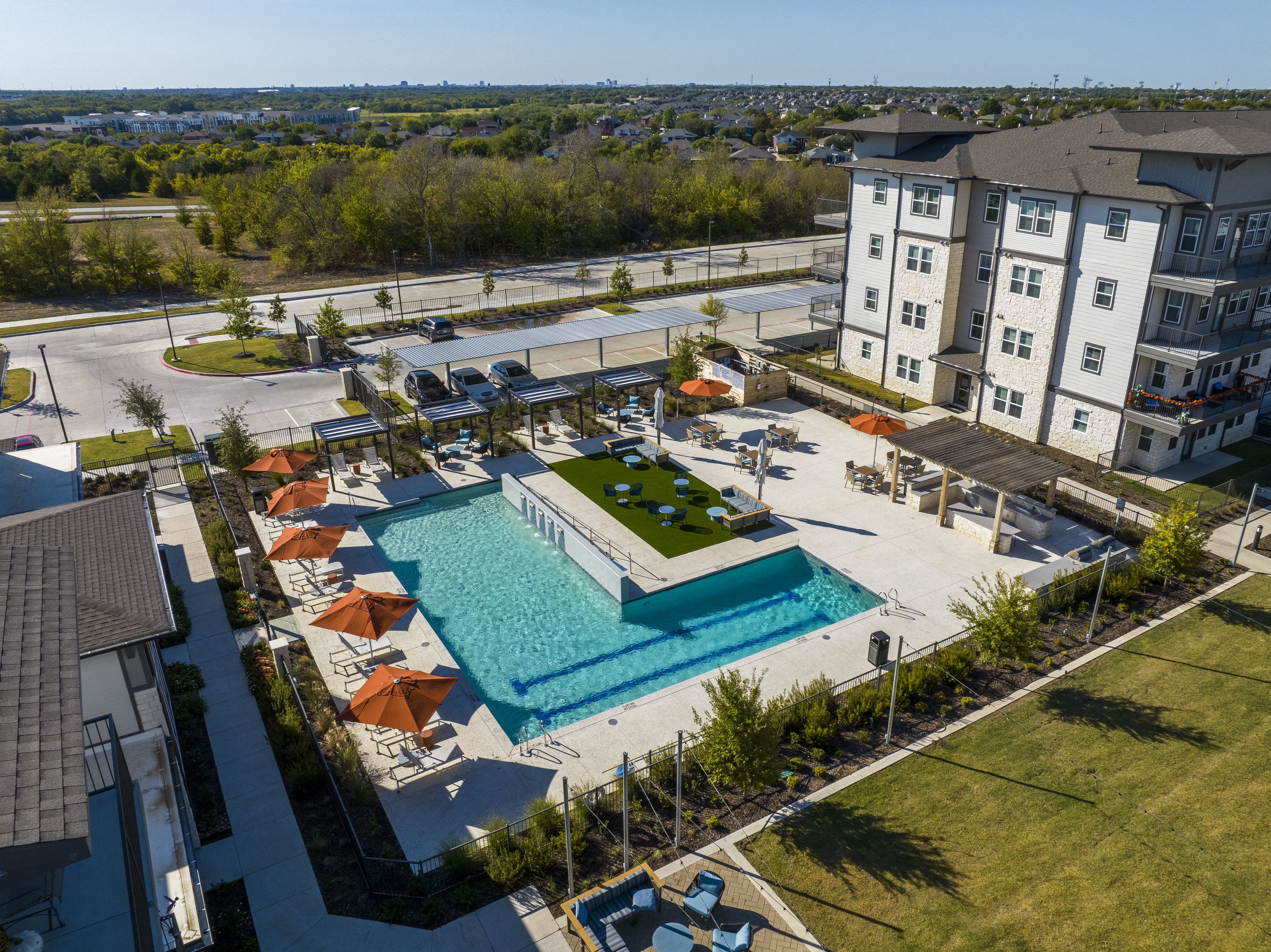 an aerial view of an apartment complex with a resort-style pool and outdoor courtyard at a senior apartment community